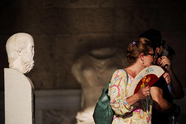August 27, 2026, Athens, Greece: A tourist uses a hand fan to cool herself next to an ancient statue while visiting the Stoa of Attalos at the Ancient Agora of Athens during hot summer weather. Athens Greece - ZUMAthen 20260827_mda_x103_782 Copyright: xHarrisxXanthopoulosx