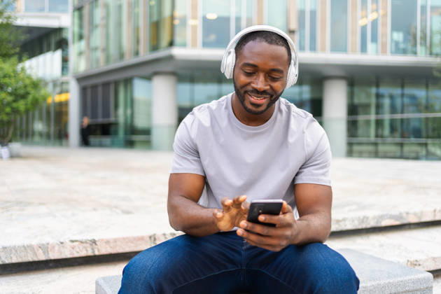 Musik-Song-Konzept. Ein guter Start in den Tag. Ein fröhlicher Afroamerikaner, der einen modernen Hit hört und Spaß auf den Straßen der Stadt hat. Ein junger, gutaussehender Mann mit Kopfhörern, der es genießt, seine Lieblingsmusik auf dem Handy zu hören. Musik-Song-Konzept. Guten Starttag. Glücklicher afrikanischer amerikanischer Mann hören modernen Hit auf der Straße in der Stadt. Personen, die Kopfhörer tragen, genießen das Zuhören Lieblingsmusik am Telefon. Menschen Lifestyle Freude (License=RF) ,model released, Symbolfoto Copyright: xZoonar.com IuliiaxZavalishinax 25493369 ,model released, Symbolfoto ,property released