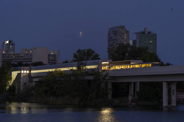 Moon during partial eclipse seen from Austria™s capital Vienna, in frame is the subway station Alte Donau. Vienna Vienna Austria