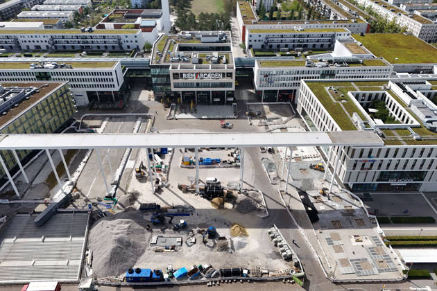 Redesign of Willy Brandt Platz at the Riem Arcaden: Sealed Surfaces Are Being Converted into Green Spaces Construction work is underway to redesign Willy Brandt Platz in front of the Riem Arcaden in Munich. As part of the redesign, previously sealed surfaces will be unsealed and replaced with green spaces. Construction barriers