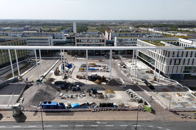 Redesign of Willy Brandt Platz at the Riem Arcaden: Sealed Surfaces Are Being Converted into Green Spaces Construction work is underway to redesign Willy Brandt Platz in front of the Riem Arcaden in Munich. As part of the redesign, previously sealed surfaces will be unsealed and replaced with green spaces. Construction barriers
