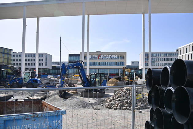 Redesign of Willy Brandt Platz at the Riem Arcaden: Sealed Surfaces Are Being Converted into Green Spaces Construction work is underway to redesign Willy Brandt Platz in front of the Riem Arcaden in Munich. As part of the redesign, previously sealed surfaces will be unsealed and replaced with green spaces. Construction barriers