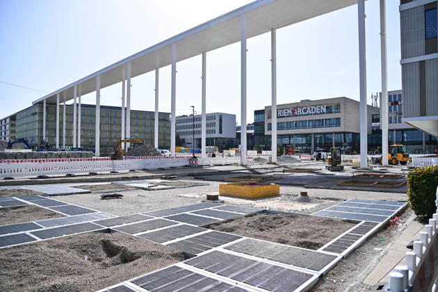Redesign of Willy Brandt Platz at the Riem Arcaden: Sealed Surfaces Are Being Converted into Green Spaces Construction work is underway to redesign Willy Brandt Platz in front of the Riem Arcaden in Munich. As part of the redesign, previously sealed surfaces will be unsealed and replaced with green spaces. Construction barriers