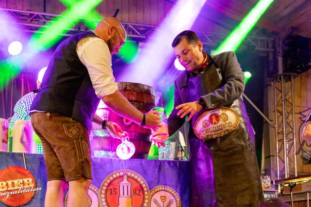 Augsburg, Bavaria, Germany August 28, 2026: Opening of the Plärrer in Augsburg. After the traditional tapping of the keg, free beer is served at the Augsburg Herbstplärrer. Visitors hold out their beer mugs toward the stage and have beer poured directly from the keg