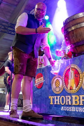 Augsburg, Bavaria, Germany August 28, 2026: Opening of the Plärrer in Augsburg. After the traditional tapping of the keg, free beer is served at the Augsburg Herbstplärrer. Visitors hold out their beer mugs toward the stage and have beer poured directly from the keg