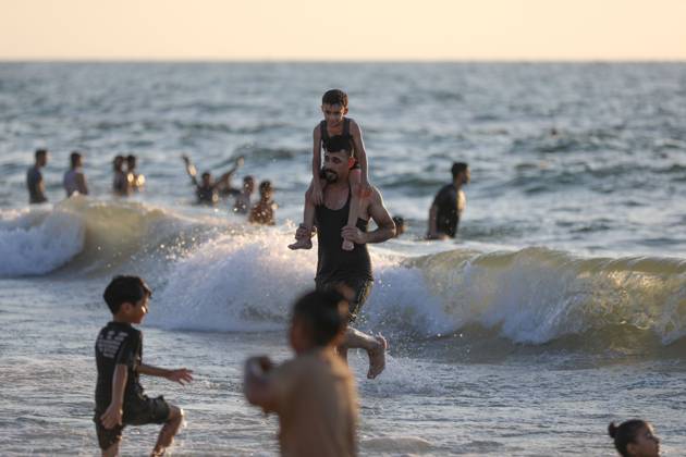 August 29, 2026, Nuseirat, Palestine, State of: NUSEIRAT, GAZA STRIP, PALESTINE, AUGUST 2026: Palestinians gather along the beach in Nuseirat seeking relief from the summer heat as high temperatures add to difficult living conditions for displaced families staying in tents. Residents spend time by the sea as a respite from the heat and the hardships of daily life in the Gaza Strip. Nuseirat Palestine, State of - ZUMAq101 20260829_zna_q101_023 Copyright: xRamzixAbuxAmerx