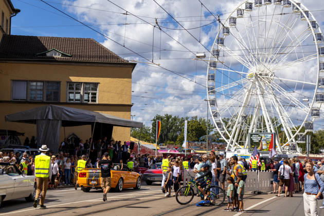 Augsburg, Bavaria, Germany - August 29, 2026: Traditional Plärrer parade in Augsburg. The traditional Plärrer parade reaches the festival grounds in Augsburg. Numerous spectators watch the parade of decorated floats, while the Plärrer s Ferris wheel can be seen in the background