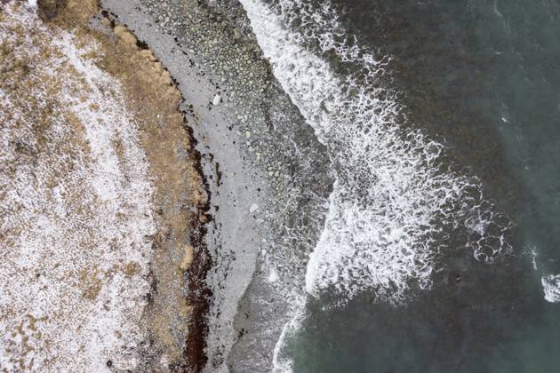 Creative Highlights World Luftaufnahme einer verschneiten Küste mit schaumigen Wellen, die auf das Land treffen, und strukturierten Oberflächen, Lyngenalpen, Tromsø, arktisches Norwegen Aerial perspective of a snowy shoreline with frothy waves meeting the land and textured surfaces, Lyngen Alps, Tromsoe, arctic Norway Copyright: imageBROKER NordicImages iblzru18658230.jpg