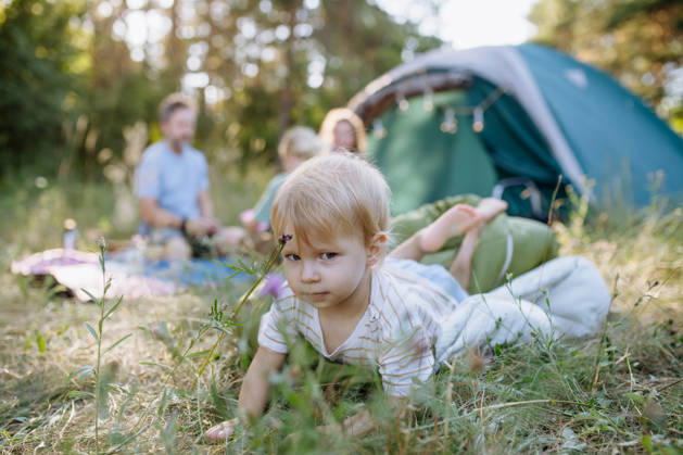 Happy family spending time together during summer camping trip. Happy parents and children bonding during camping adventure. model released