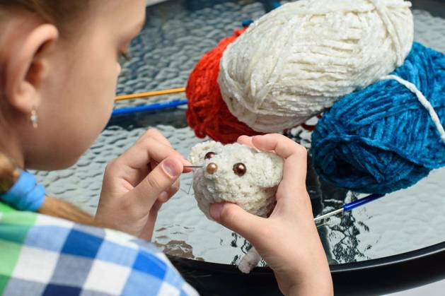 Girl sews on the eyes of a homemade soft toy mouse model released Symbolfoto Copyright: xMadhoursex Panthermedia79270900.jpg