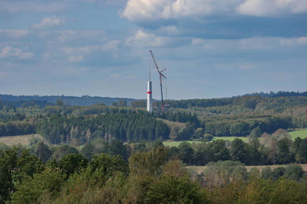 A new wind turbine is being built near Freudenberg. Work is underway. Part of the tower is already in place, and a telescopic crane stands next to it. Wind turbine construction in the Siegerland region on September 10, 2026, in Freudenberg, Germany