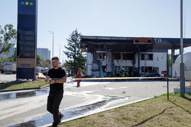 A man cordons off the premises of a petrol station attacked by a Russian drone in the Holosiivskyi district of Kyiv, Ukraine, September 10, 2026. Russian forces targeted the petrol station, injuring four people. A car caught fire on the premises, and a public transport stop was also damaged. (Photo by Marianna Kotyk Ukrinform) Russian drone strikes petrol station in Kyiv’s Holosiivskyi district  Copyright: xMariannaxKotykx