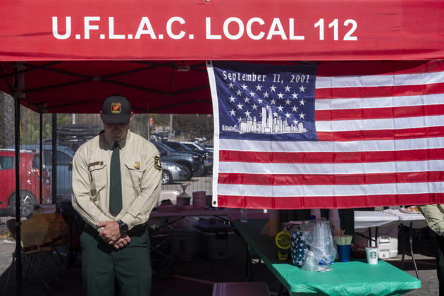 September 11, 2026, Los Angeles, California, USA: A member of the U.S. Forest Service stands next to a 9 11 remembrance flag as the Los Angeles Fire Department marks the 25th anniversary of the Sept. 11 terrorist attacks at the Frank Hotchkin Memorial Training Center in Los Angeles, California, on Sept. 11, 2026. Los Angeles USA  - ZUMAc68_ 20260911_zaf_c68_016 Copyright: xRingoxChiux