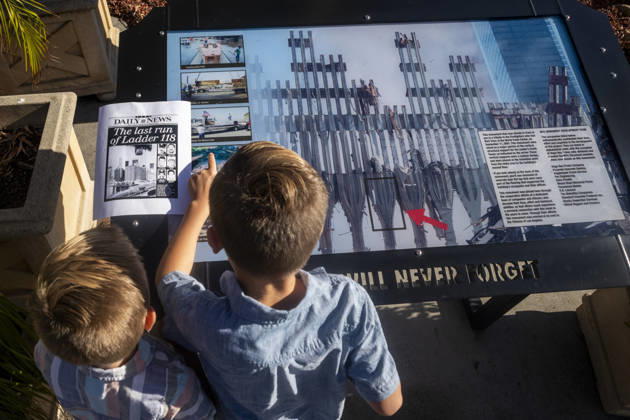 September 11, 2026, Los Angeles, California, USA: Two children examine a 9 11 memorial display featuring images of the World Trade Center site as the Los Angeles Fire Department marks the 25th anniversary of the terrorist attacks at the Frank Hotchkin Memorial Training Center in Los Angeles, California, on Sept. 11, 2026. Los Angeles USA - ZUMAc68_ 20260911_zaf_c68_008 Copyright: xRingoxChiux