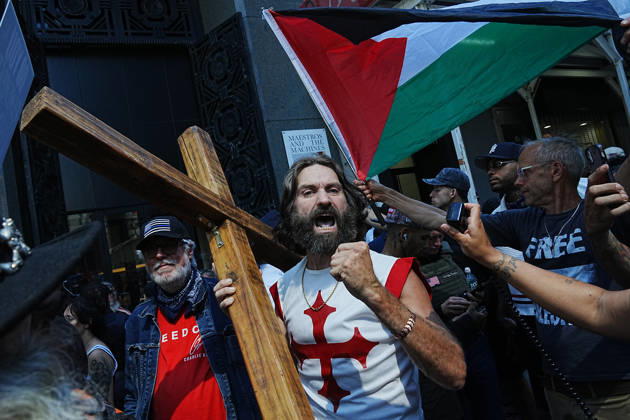 News Bilder des Tages #2 September 11, 2026, New York, New York, USA: A man carrying a cross chants as part of an anti-Muslim rally lead by white supremacist JAKE LANG near the 9 11 Memorial on the 25th anniversary of the attacks of September 11 on September 11, 2026 in New York. New York USA - ZUMAb148 20260911_zap_b148_020 Copyright: xBryanxSmithx