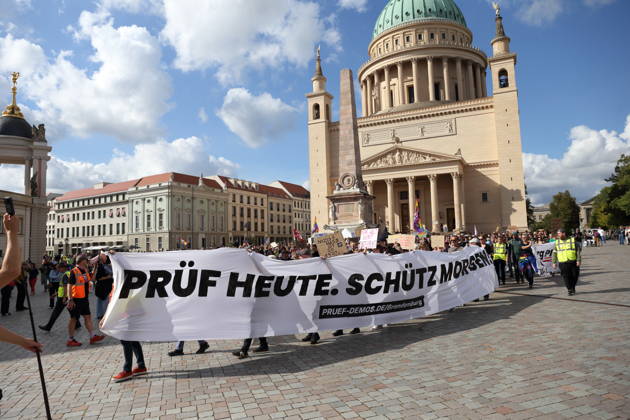 Protesters carrying a banner reading Review today, ban tomorrow march around the state parliament during a demonstration calling for the Federal Constitutional Court to review far-right parties, Alter Markt, Potsdam, September 12, 2026. Review demonstration in Potsdam