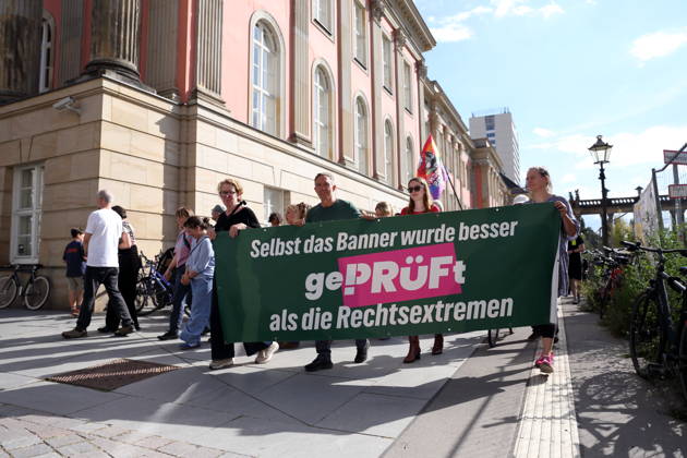 Protesters march with a banner. Even the banner was scrutinized more closely than the far-right extremists as they gathered around the state parliament during a demonstration calling for the Federal Constitutional Court to review far-right parties, Alter Markt, Potsdam, September 12, 2026. Protest in Potsdam
