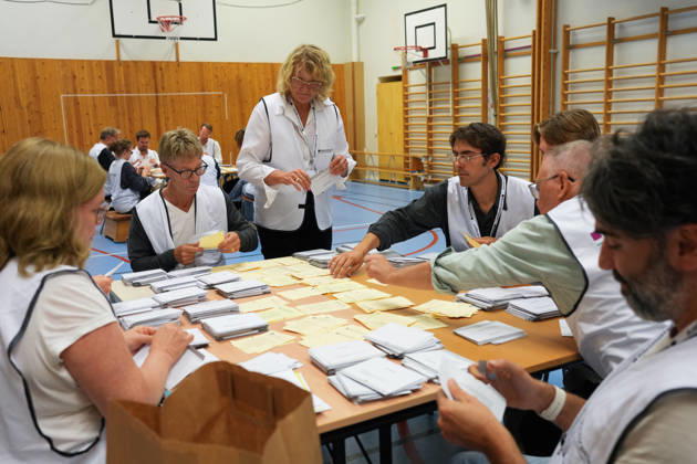 (260914) -- STOCKHOLM, Sept. 14, 2026 -- Staff members count ballots at a counting station in Stockholm, Sweden, Sept. 13, 2026. Polling stations opened across Sweden on Sunday morning in a closely watched parliamentary election that could see the far-right Sweden Democrats (SD) enter government for the first time or the center-left return to power after four years in opposition. The opposition bloc held a lead over the right-wing bloc in two exit polls released after voting ended in Sunday s parliamentary election. Public broadcaster SVT s exit poll put the four opposition parties at 51.3 percent of the vote, against 46.8 percent for the four right-wing parties. A separate election-day survey by TV4 showed a similar picture, giving 