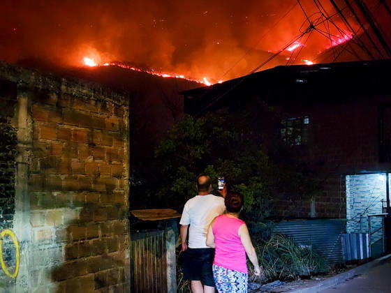 Wildfire puts Cali community in Altos de Menga neighborhood at risk CALI, COLOMBIA - SEPTEMBER 17: Firefighters and local residents work together to battle a fast-moving wildfire threatening homes in the Altos de Menga neighborhood in northern Cali, Colombia on September 17, 2026. Fueled by prolonged dry conditions, lack of rainfall, and strong winds, the blaze tore through hillside vegetation, impacting at least five homes and sending large plumes of smoke across the city as emergency crews navigated difficult mountainous terrain to contain the spread. Edwin Rodriguez Pipicano Anadolu Cali Colombia. Editorial use only. Please get in touch for any other usage.  Copyright: x2026xAnadoluxEdwinxRodriguezxPipicanox
