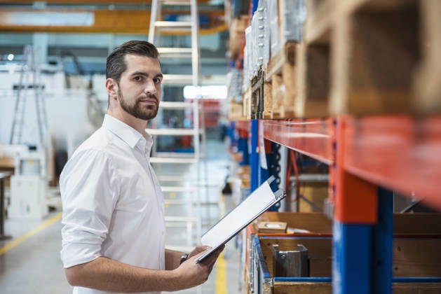 A male manager inspects inventory in a warehouse model released, Symbolfoto property released, DIGF27720
