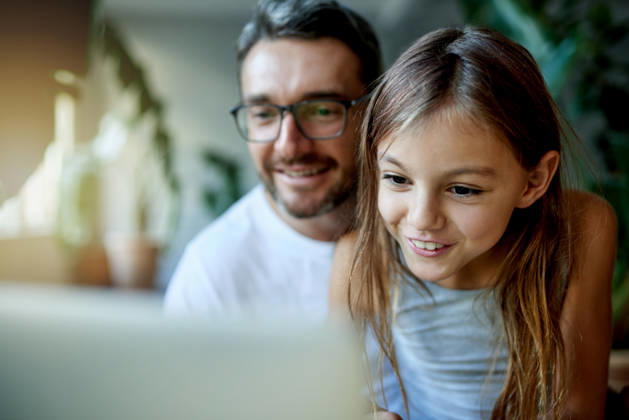 Streaming, dad and child with smile on laptop in home, watch cartoon movie or bonding on weekend. Mature man, happy girl or entertainment on film subscription site, tech or love for family connection. model released property released Copyright: xx