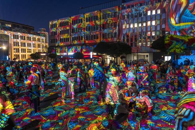 Essen Light Festival, in the city center; the light installation Diving in the Sea of Colors by Berlin-based artist Daniel Margraf illuminates the buildings on the large Kennedy Platz; visitors become part of the light art installation; North Rhine-Westphalia, Germany; Essen Light Festival