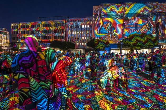 Essen Light Festival, in the city center; the light installation Diving in the Sea of Colors by Berlin-based artist Daniel Margraf illuminates the buildings on the large Kennedy Platz; visitors become part of the light art installation; North Rhine-Westphalia, Germany; Essen Light Festival