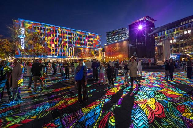 Essen Light Festival, in the city center; the light installation Diving in the Sea of Colors by Berlin-based artist Daniel Margraf illuminates the buildings on the large Kennedy Platz; visitors become part of the light art installation; North Rhine-Westphalia, Germany; Essen Light Festival