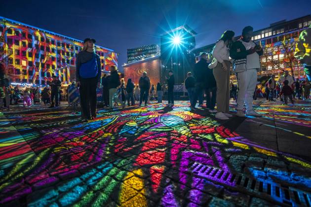 Essen Light Festival, in the city center; the light installation Diving in the Sea of Colors by Berlin-based artist Daniel Margraf illuminates the buildings on the large Kennedy Platz; visitors become part of the light art installation; North Rhine-Westphalia, Germany; Essen Light Festival