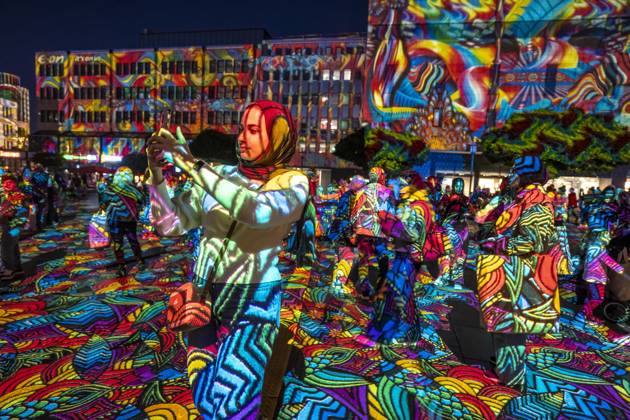 Essen Light Festival, in the city center; the light installation Diving in the Sea of Colors by Berlin-based artist Daniel Margraf illuminates the buildings on the large Kennedy Platz; visitors become part of the light art installation; North Rhine-Westphalia, Germany; Essen Light Festival