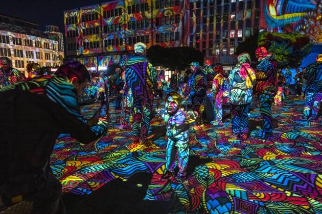 Essen Light Festival, in the city center; the light installation Diving in the Sea of Colors by Berlin-based artist Daniel Margraf illuminates the buildings on the large Kennedy Platz; visitors become part of the light art installation; North Rhine-Westphalia, Germany; Essen Light Festival