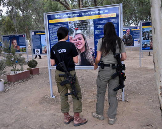 Israeli soldiers look at a photo of a victim killed by Hamas on October 7, 2023, at the Nova Festival Memorial site in Re im, near the Gaza border on Monday, October 6, 2026. Israel is marking three years since the Hamas attack that killed 1,200 people and 251 were taken hostage into Gaza.  JER2026100618 DEBBIExHILL