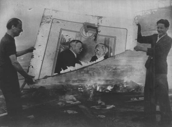 Communist Emblems Burned in Berlin - Two rioters yesterday burning a communist placed. On this molotov is depicted shaking hands with an East German leader. After the riots which rocked East Berlin yesterday, the Russians have sealed off their sector of the City. Reports today speak of continuing intermittent gun-fire. It is estimated that there are now 12,000 troops and 260 tanks in the Russian sector of the city. June 18, 1953. (Photo by Paul Popper).  Copyright: xPaulxPopperx 5513-75518850