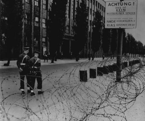 British Besiege Communist Radio Station Two British military policemen patrol inside a barbed wire cordon which was thrown round the Russian-operated radio Berlin in the British sector of the city early morning, June 3. German police are on guard in the background. This action by the British is a counter-move after communists seized hamlets on the borders of the city. For years the communists have been broadcasting anti-western Propaganda from this station. June 3, 1952. (Photo by Associated Press Photo).  Copyright: xAssociatedxPressxPhotox 5513-76011678