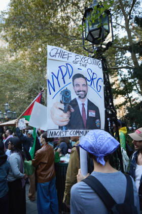 October 7, 2026, New York, New York, USA: A demonstrator wearing a keffiyeh holds a poster during a pro-Palestinian protest at City Hall Park in New York City, New York. New York USA  - ZUMAs237 20261007_aap_s237_020 Copyright: xMarkxJ.xSullivanx