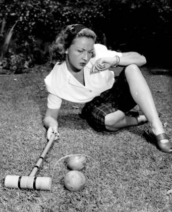 Lawn Golfer -- Actress Bonita Granville is having a wicket time determining her next move in a croquet match. Anyway, she looks good in her Plaid Peddle-pushers and White Blouse. October 8, 1947. (Photo by Wide World Photos).  Copyright: xWidexWorldxPhotosx 5513-78877885