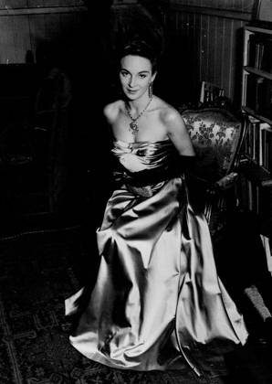 Joan in Pale Gold -- Actress Joan Greenwood will wear this pale gold gown for her presentation to the Royal Party at the Royal Film Performance on Monday. It has a tiny pleated bodice and a very full skirt. With it she wears on ostrich feathered headdress. October 25, 1952.  Copyright: xEveningxNewsx 5513-78878061
