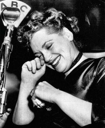 Tearful Winner -- Judy Holliday wipes a tear of happiness from her eye as she stands at microphone in New York night club tonight after hearing announcement that she had won the Oscar for the best 1950 motion picture performance by an actress. She gained the award for her performance as the dumb blonde in Born Yesterday. March 29, 1951. (Photo by AP Wirephoto).  Copyright: xAPxWirephotox 5513-85306250