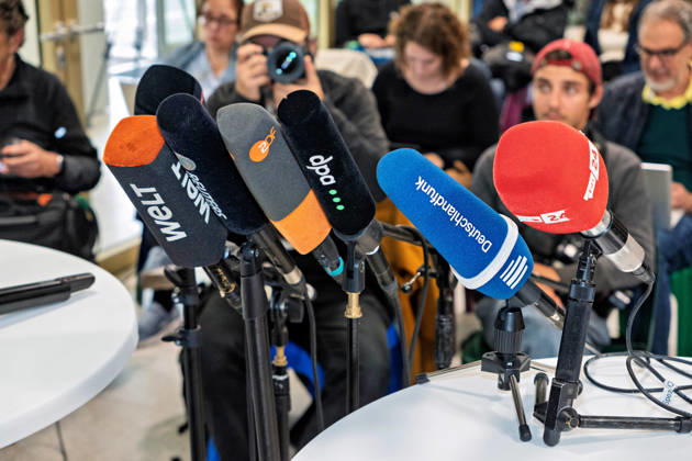 Berlin, October 8, 2026: Media outlets from around the world, ZDF, dpa, Deutschlandfunk, and rbb24 are gathered in the foyer of the Haus der Statistik ahead of the joint press statement by Die Linke Berlin, Bündnis 90 Die Grünen Berlin, and SPD Berlin following the conclusion of preliminary talks; behind them, journalists await the press statement from Die Linke, the Greens, and the SPD in Berlin
