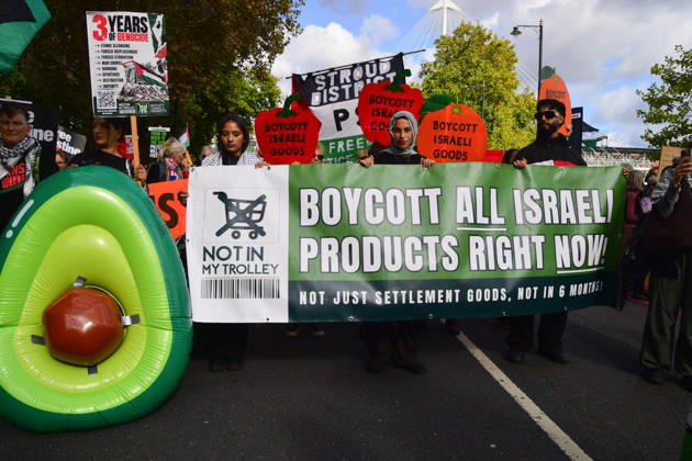 October 10, 2026, London, England, United Kingdom: Protesters hold a Boycott all Israeli products banner as thousands of people march in Westminster in support of Palestine. The protesters also called on the government to stop arming Israel and for sanctions on Israel. London United Kingdom - ZUMAv130 20261010_zip_v130_004 Copyright: xVukxValcicx