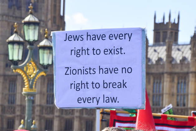 October 10, 2026, London, England, United Kingdom: A protester on Westminster Bridge holds a sign stating Jews have every right to exist, Zionists have no right to break every law as thousands of people march in support of Palestine. The protesters also called on the government to stop arming Israel and for sanctions on Israel. London United Kingdom  - ZUMAv130 20261010_zip_v130_035 Copyright: xVukxValcicx