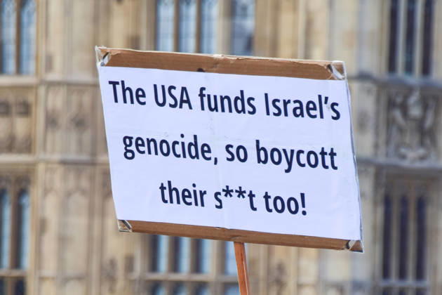October 10, 2026, London, England, United Kingdom: A protester on Westminster Bridge holds a sign calling for a boycott of the USA as thousands of people march in support of Palestine. The protesters also called on the government to stop arming Israel and for sanctions on Israel. London United Kingdom  - ZUMAv130 20261010_zip_v130_040 Copyright: xVukxValcicx