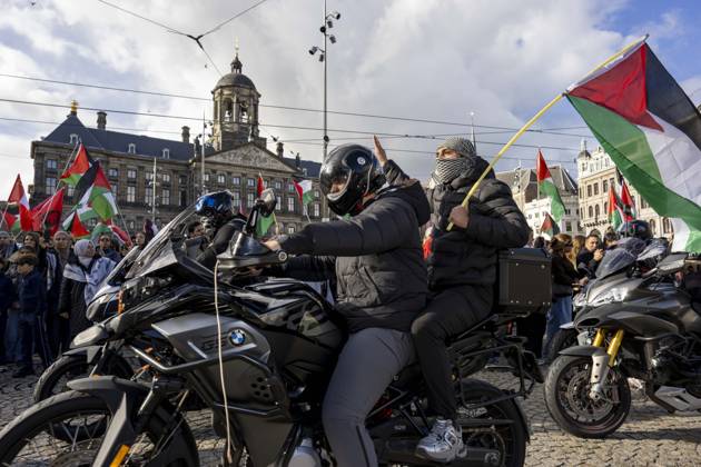 October 11, 2026, Amsterdam, Noord-Holland, The Netherlands: October 11, 2026, Amsterdam, Netherlands: A motorcycle passenger holds a Palestinian flag and raises one hand during a pro-Palestinian protest at Dam Square, with the Royal Palace of Amsterdam in the background. Amsterdam The Netherlands - ZUMAl165 20261011_zip_l165_015 Copyright: xOrinxLouisx