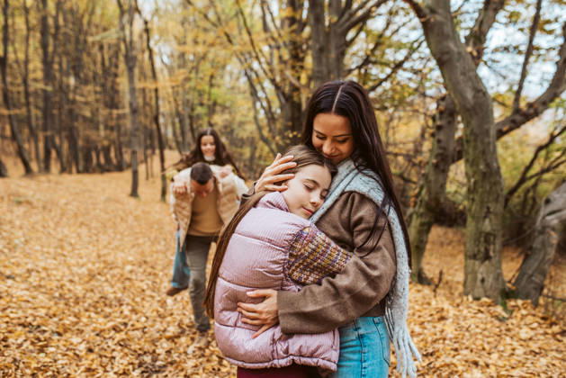 Family portrait of parents with two daughter, in the middle of autumn forest. Family portrait of parents with two daughter, standing in autumn nature. model released