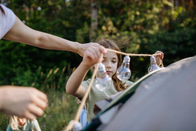 Dad and kids setting up tent together during summer camping trip. Kids and father preparing campsite for outdoor family vacation. model released