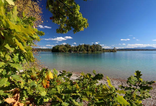 An autumn day in Feldafing, Feldafinger Park, Starnberg District. Here is a view of Lake Starnberg with Rose Island and colorful trees, foliage colors, deciduous trees, autumnal, play of colors, autumn leaves, autumn colors, leaf coloration, red, yellow, red foliage, yellow foliage, natural spectacle, autumn scene, autumn impression, weather scene, golden October