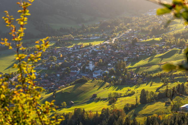 Autumn Evening in the Allgäu: The evening sun shines on the autumn landscape featuring the town of Bad Hindelang, Bad Hindelang, Bavaria, Germany