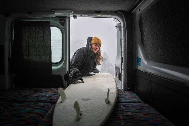 Young woman loading her snowy surfboard into a camper van Keflavík, Reykjanesbær, Iceland CR_ALEG261005-2129018-01 ,model released, Symbolfoto ,property released