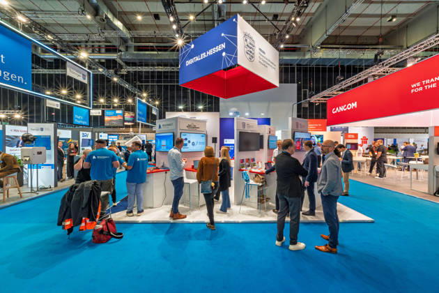 Berlin, 13.10.2026: Besucher am Stand Digitales Hessen des Hessischen Ministeriums für Digitalisierung und Innovation auf der Smart Country Convention, rechts der Stand des IT-Dienstleisters Cancom, im Hintergrund der Stand des Freistaats Thüringen. Mehrere Bundesländer stellen auf der Messe ihre Digitalstrategien und Onlinedienste für Bürger vor. Die Smart Country Convention (SCCON) ist die Kongressmesse für die Digitalisierung des öffentlichen Sektors und wird vom Digitalverband Bitkom gemeinsam mit der Messe Berlin veranstaltet. Vom 13. bis 15. Oktober 2026 treffen sich auf dem Berliner Messegelände Vertreter aus Bund, Ländern und Kommunen mit Unternehmen der Digitalwirtschaft, um über digitale Verwaltung, Smart City und