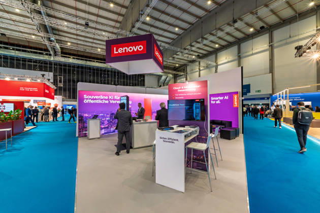 Berlin, 13.10.2026: Am Stand des Computerherstellers Lenovo auf der Smart Country Convention wirbt ein großes Display mit der Aufschrift Souveräne KI für die öffentliche Verwaltung; gezeigt werden Cloud- und Infrastrukturlösungen für kritische Infrastrukturen. Digitale Souveränität, also die Unabhängigkeit von außereuropäischen Technologieanbietern, ist eines der zentralen Themen der diesjährigen Messe. Die Smart Country Convention (SCCON) ist die Kongressmesse für die Digitalisierung des öffentlichen Sektors und wird vom Digitalverband Bitkom gemeinsam mit der Messe Berlin veranstaltet. Vom 13. bis 15. Oktober 2026 treffen sich auf dem Berliner Messegelände Vertreter aus Bund, Ländern und Kommunen mit Unternehmen der